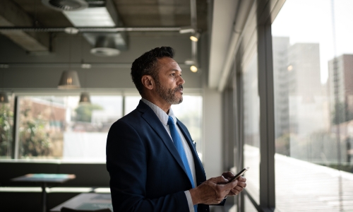 A man in an office standing at the window